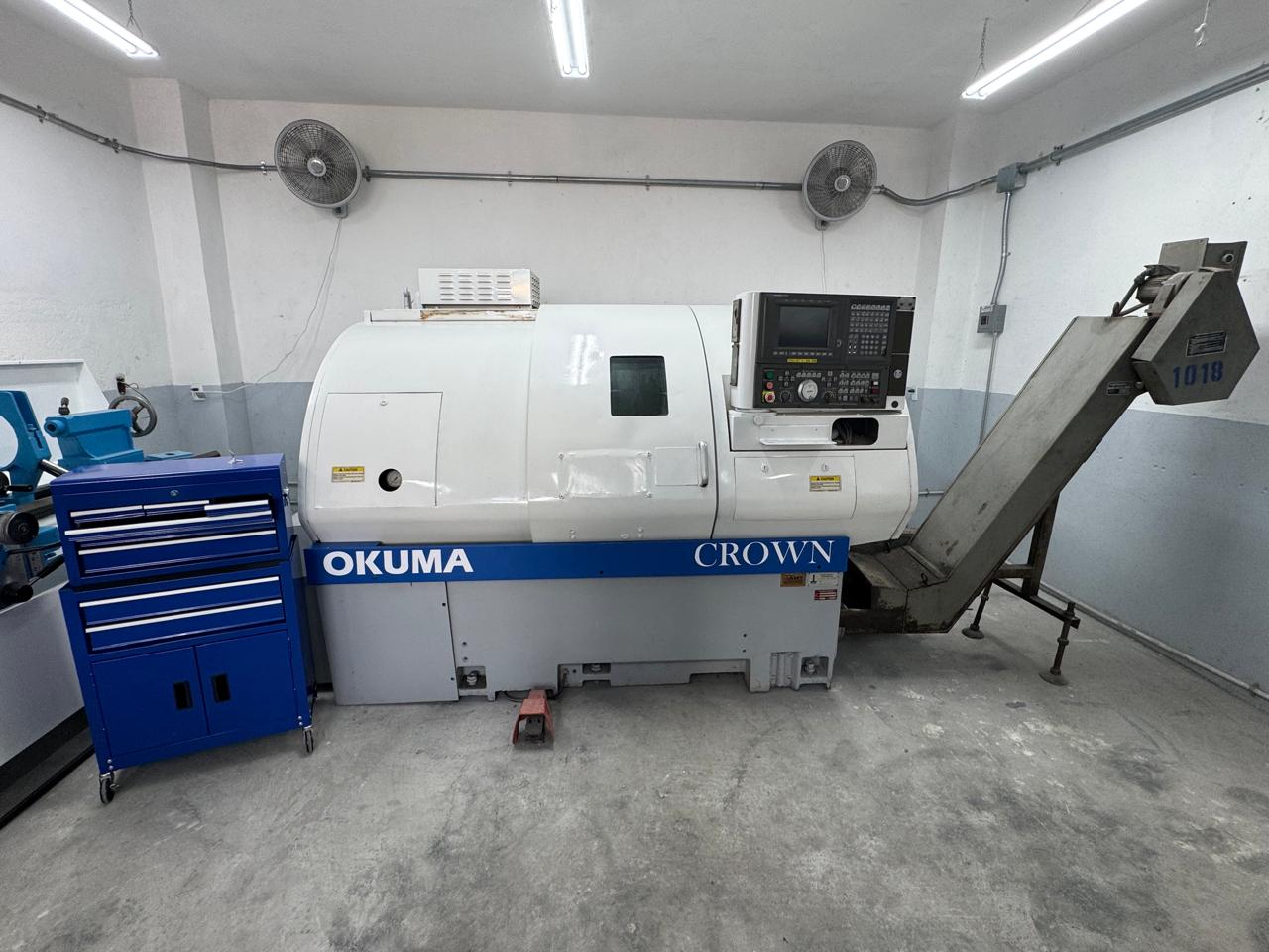 Centro de torneado CNC Okuma Crown con transportador de viruta para maquinado de precisión